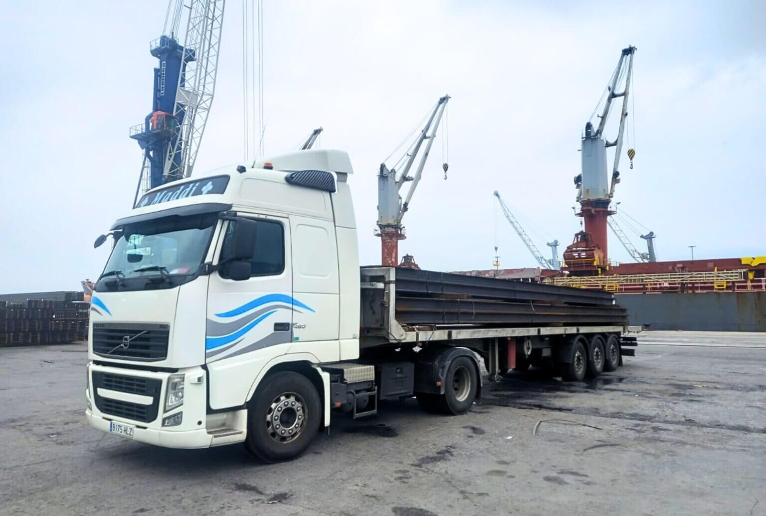 Camión de plataforma abierta de Transportes Zaldua cargando vigas de hierro desde el puerto